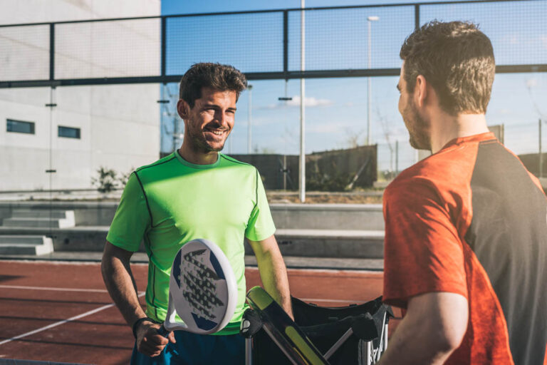 Two Men Socializing After Padel Tennis Match